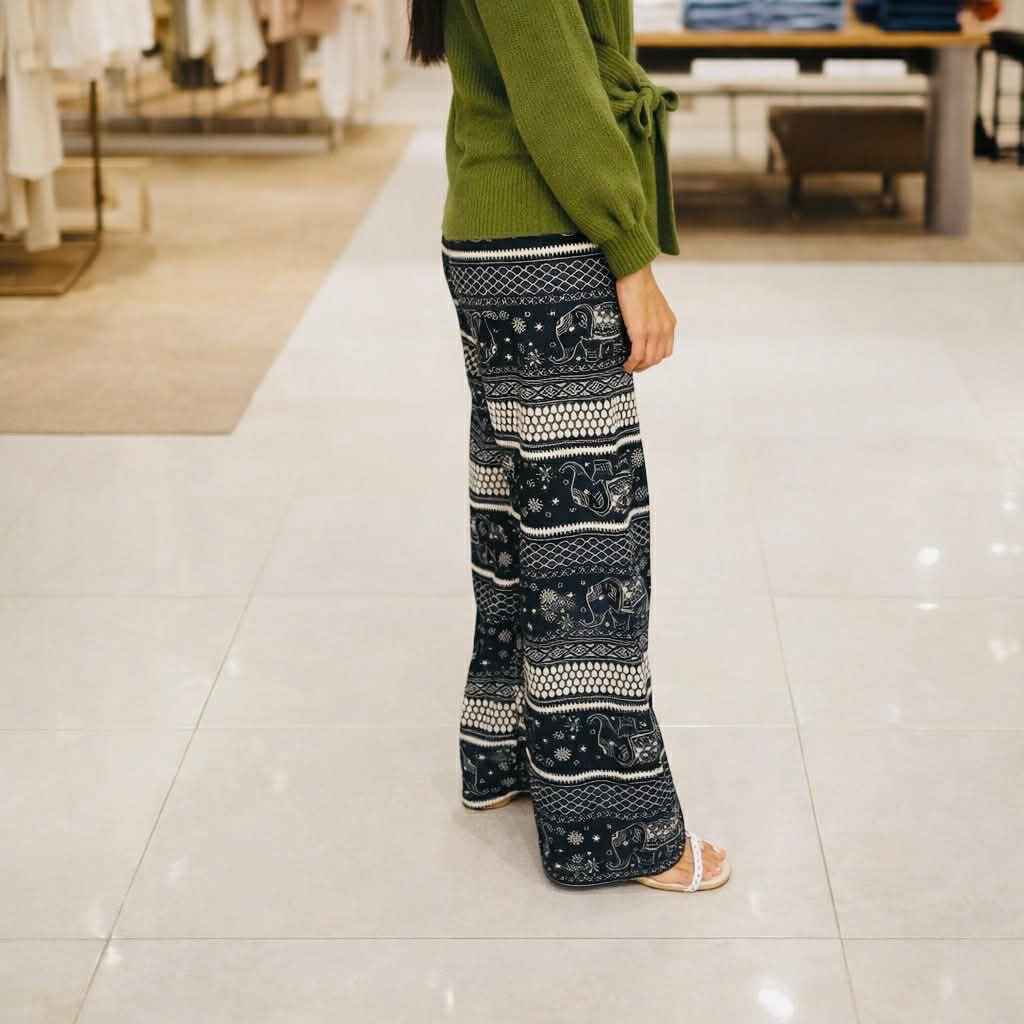 Person wearing patterned pants and a green sweater in a store setting