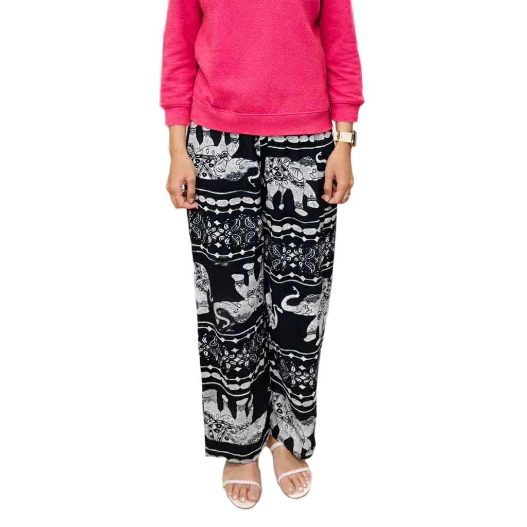 Person wearing a pink sweater and black patterned pants in a store setting