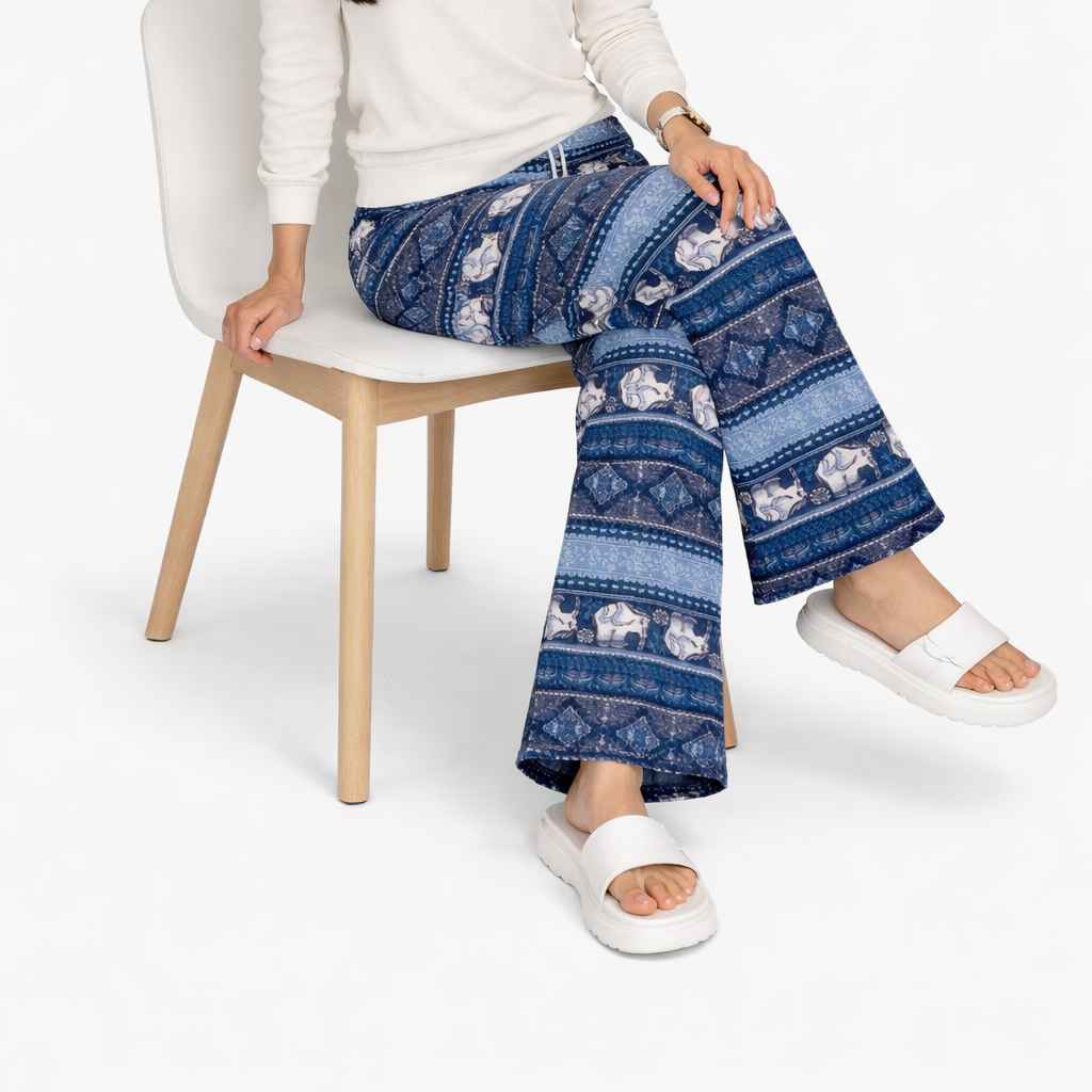 Person wearing blue patterned pants sitting on a chair with a white background