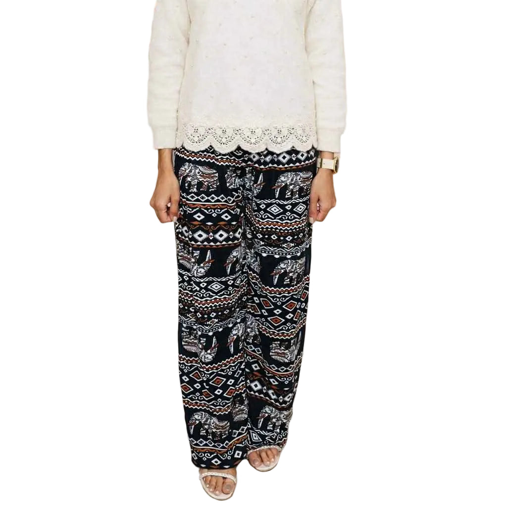 Person wearing a white lace top and patterned black pants in a store setting