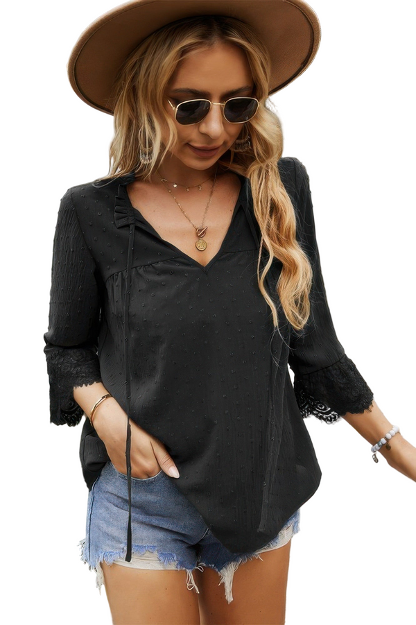 Woman wearing a black long-sleeve top, denim shorts, and a brown hat with sunglasses.