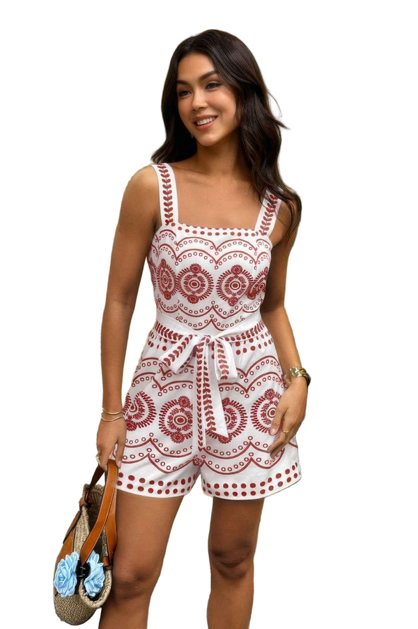 Woman wearing a white lace romper with red patterns on a white background