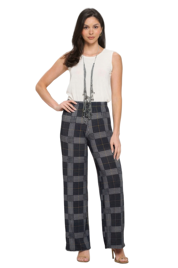 Woman wearing a white sleeveless top and plaid pants on a white background