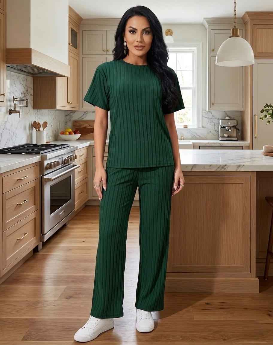 Woman in a green outfit standing in a kitchen