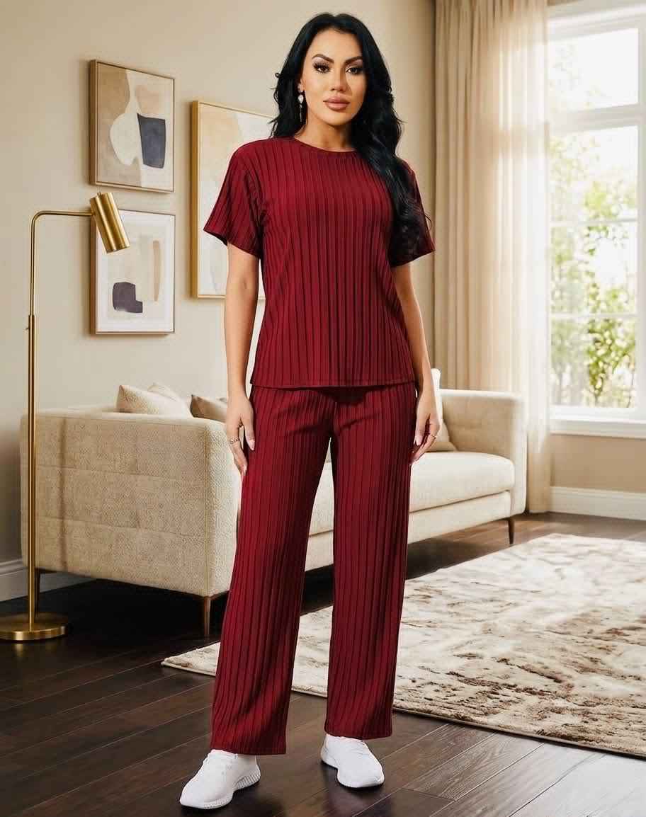 Woman in a maroon outfit standing in a living room.
